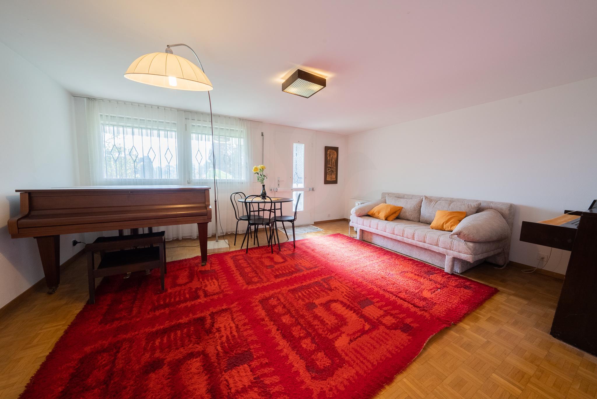 Helles Wohnzimmer mit Klavier und Sitzbereich