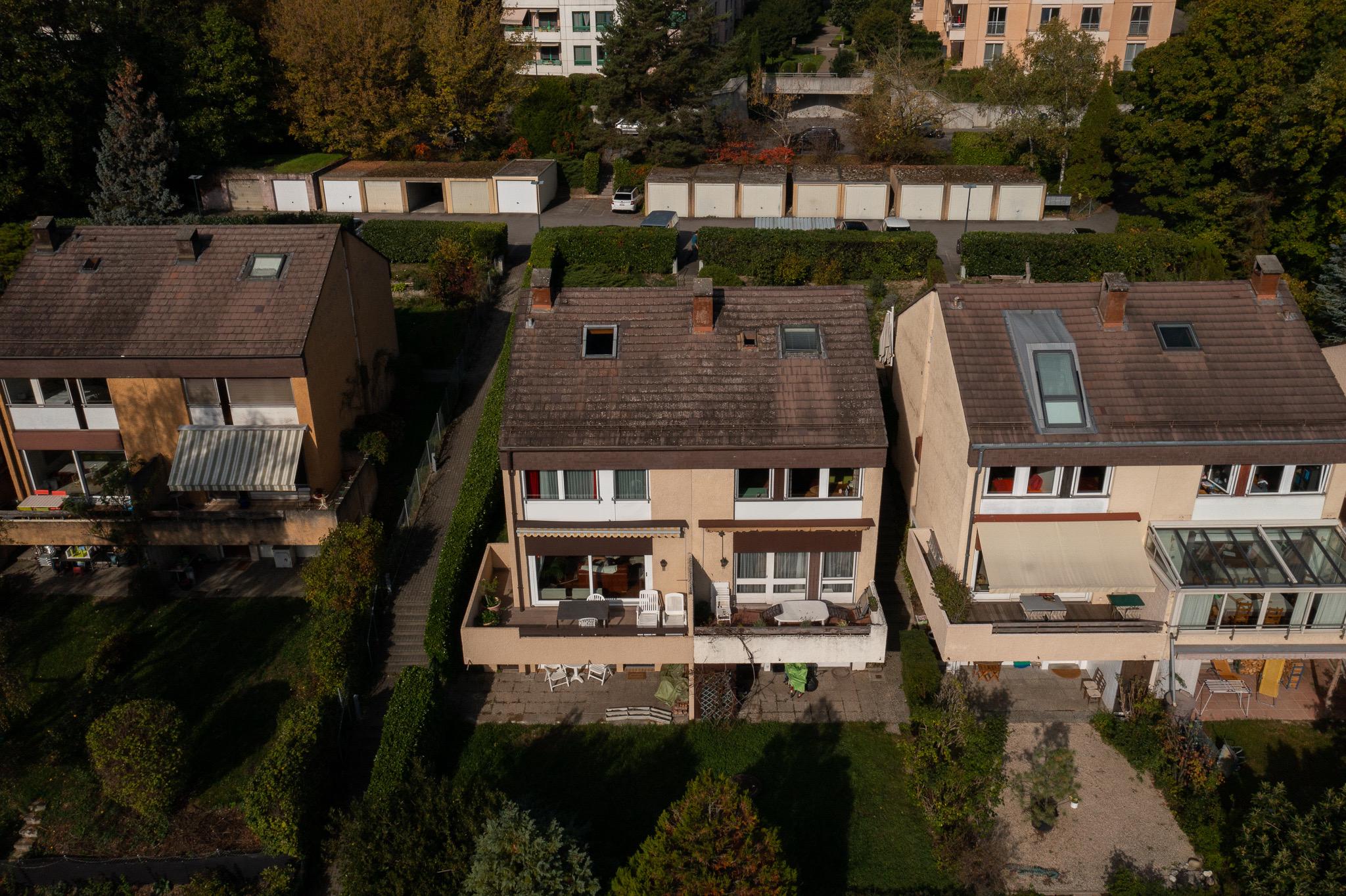 Luftaufnahme einer Reihenhausanlage mit Gärten und Garagen