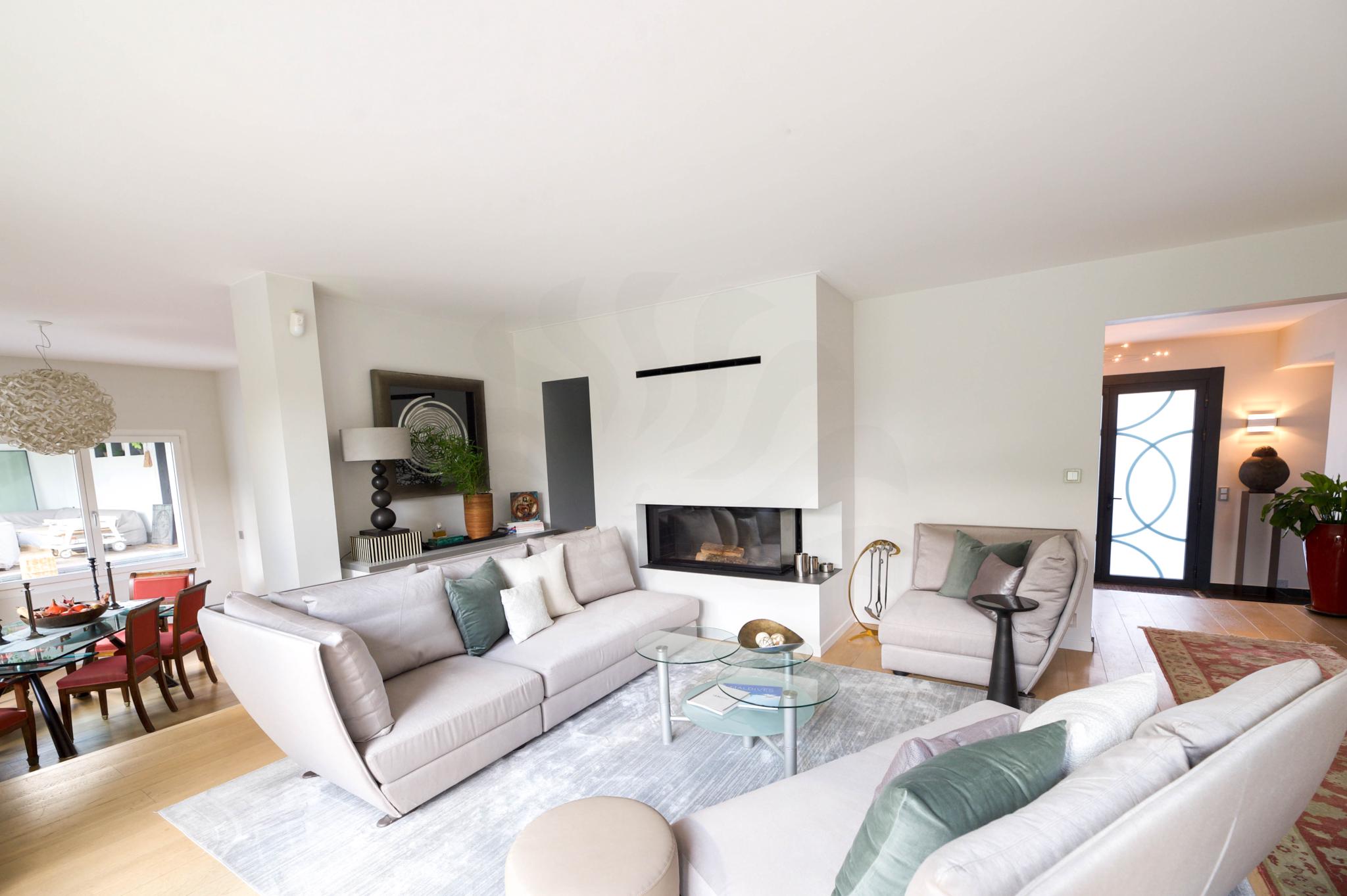 Helles, modernes Wohnzimmer mit Kamin und offener Esszone