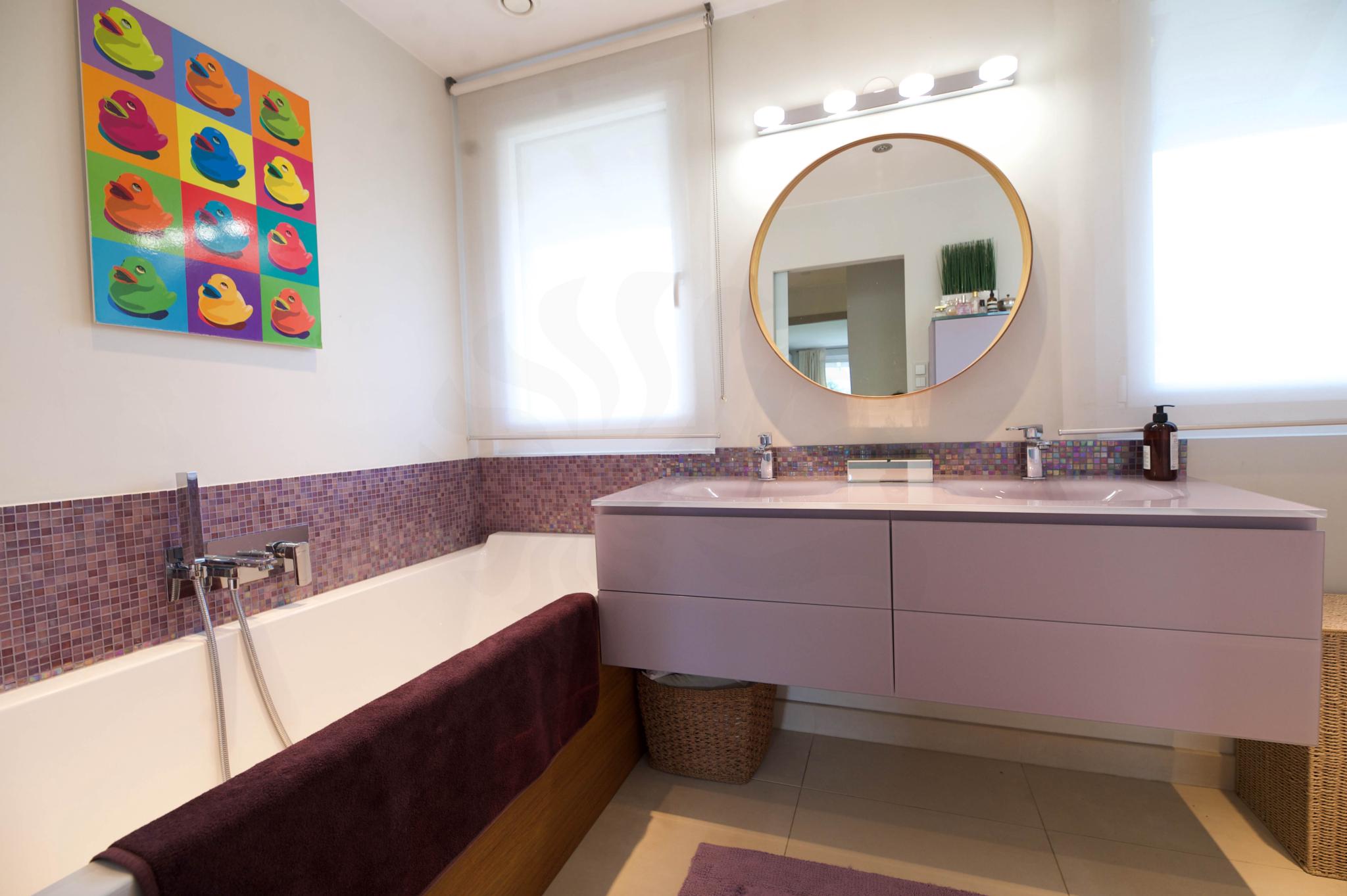 Modernes Badezimmer mit farbiger Wandkunst und Doppelwaschtisch
