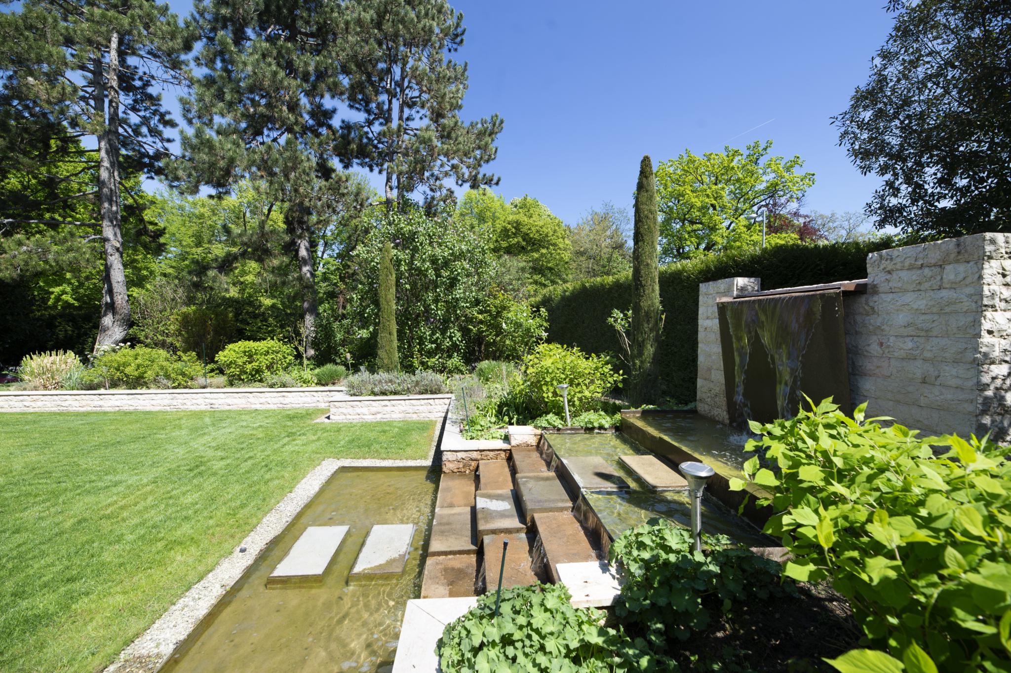 Garten mit Wasserspiel und gepflegter Bepflanzung