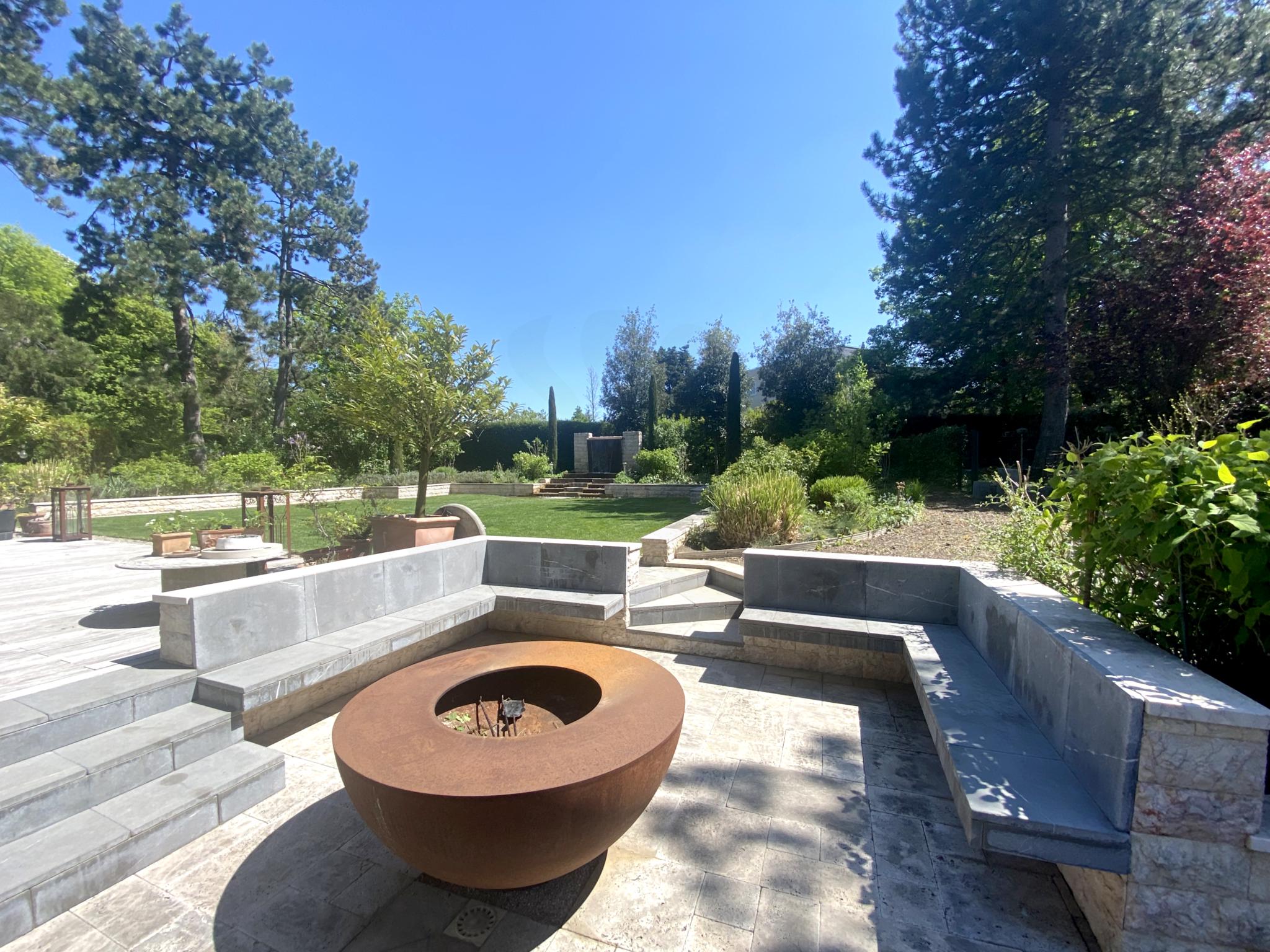 Moderner Garten mit Feuerstelle und Terrassen