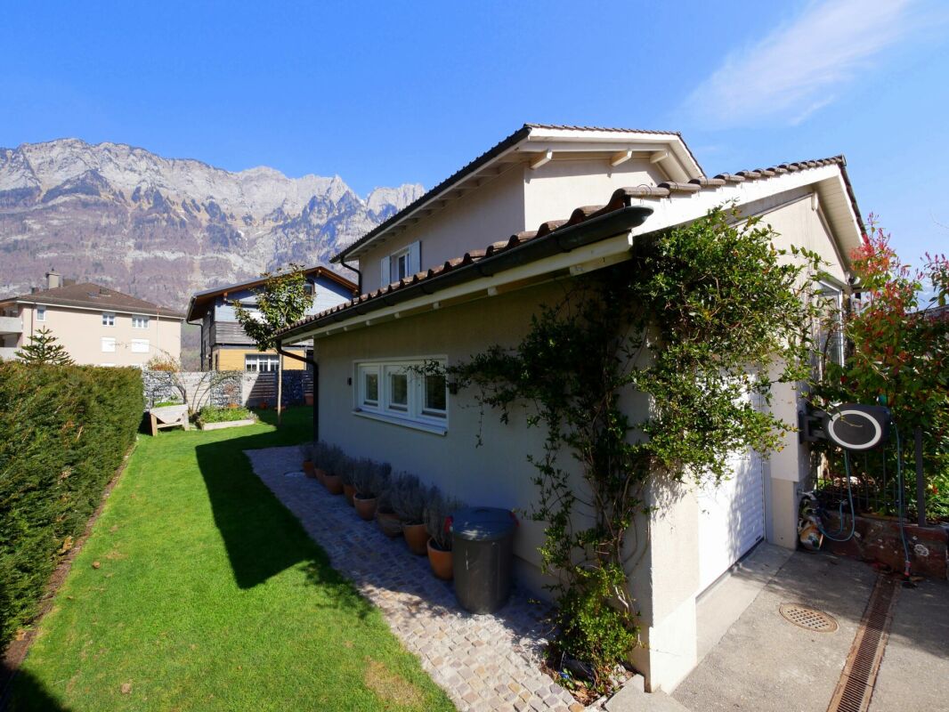 Haus mit Garten und Bergkulisse