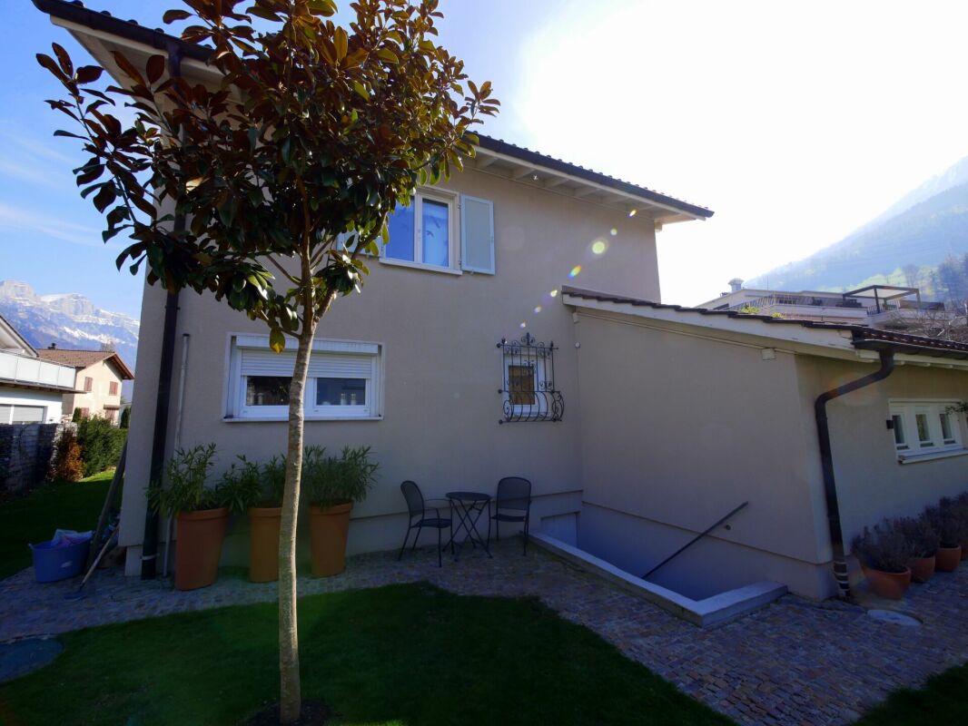 Hausansicht mit Garten und Bergkulisse