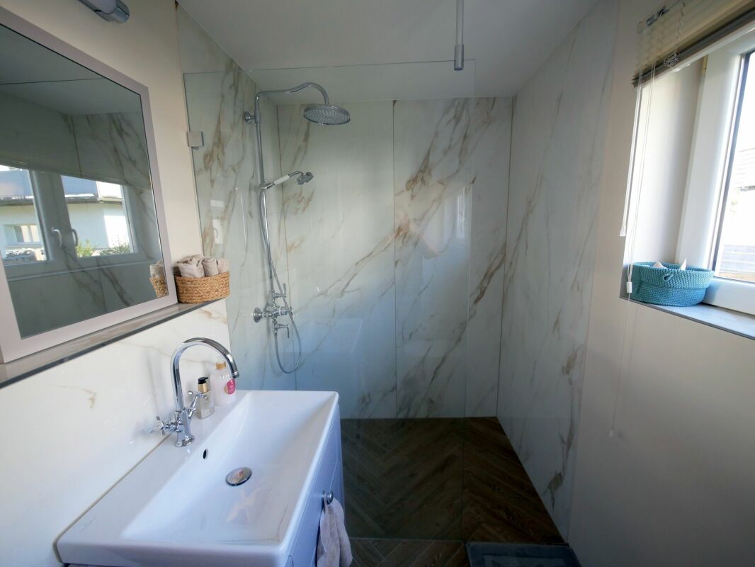 Modernes Badezimmer mit begehbarer Dusche und großem Fenster