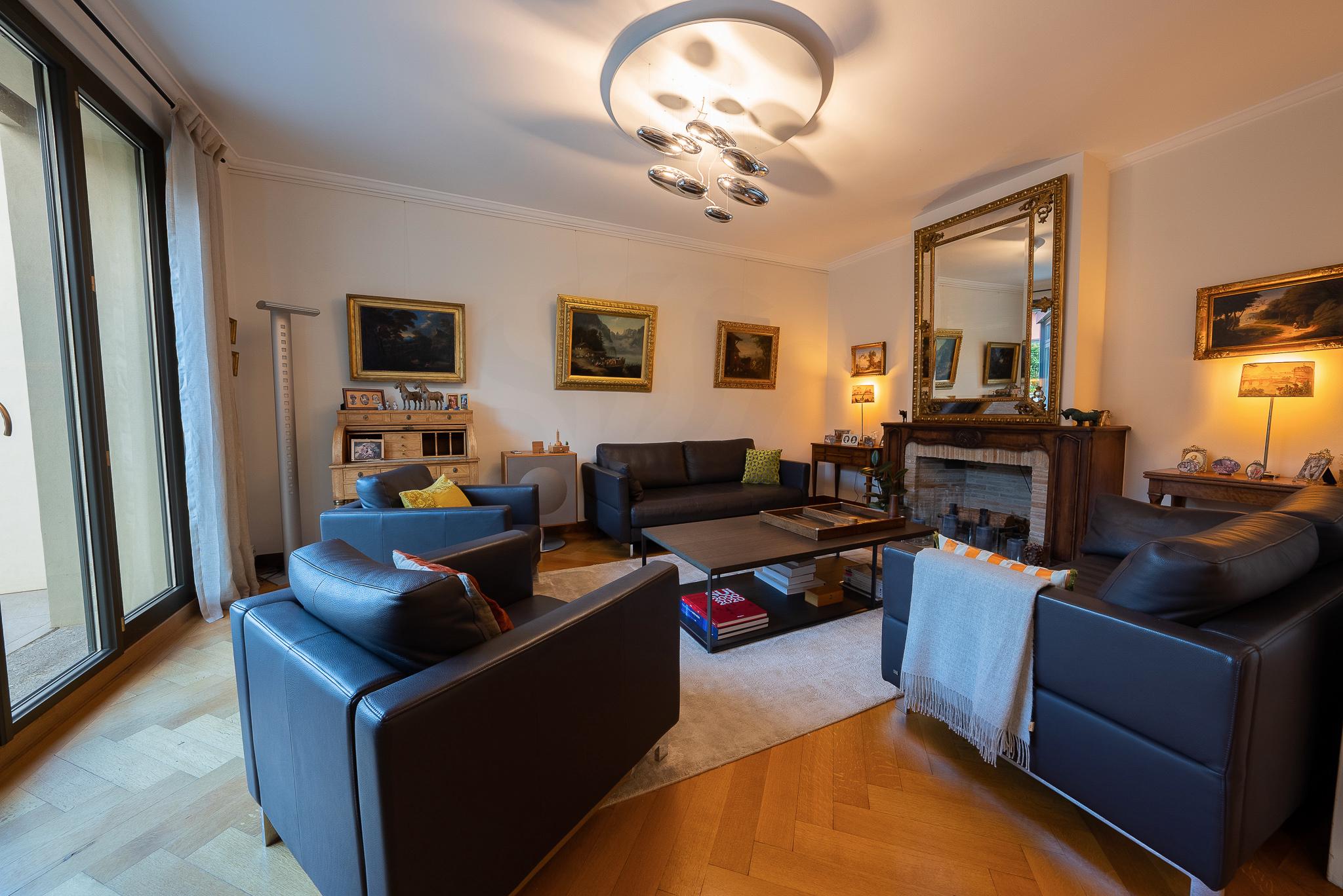 Klassisches Wohnzimmer mit Kamin und dunklen Ledermöbeln