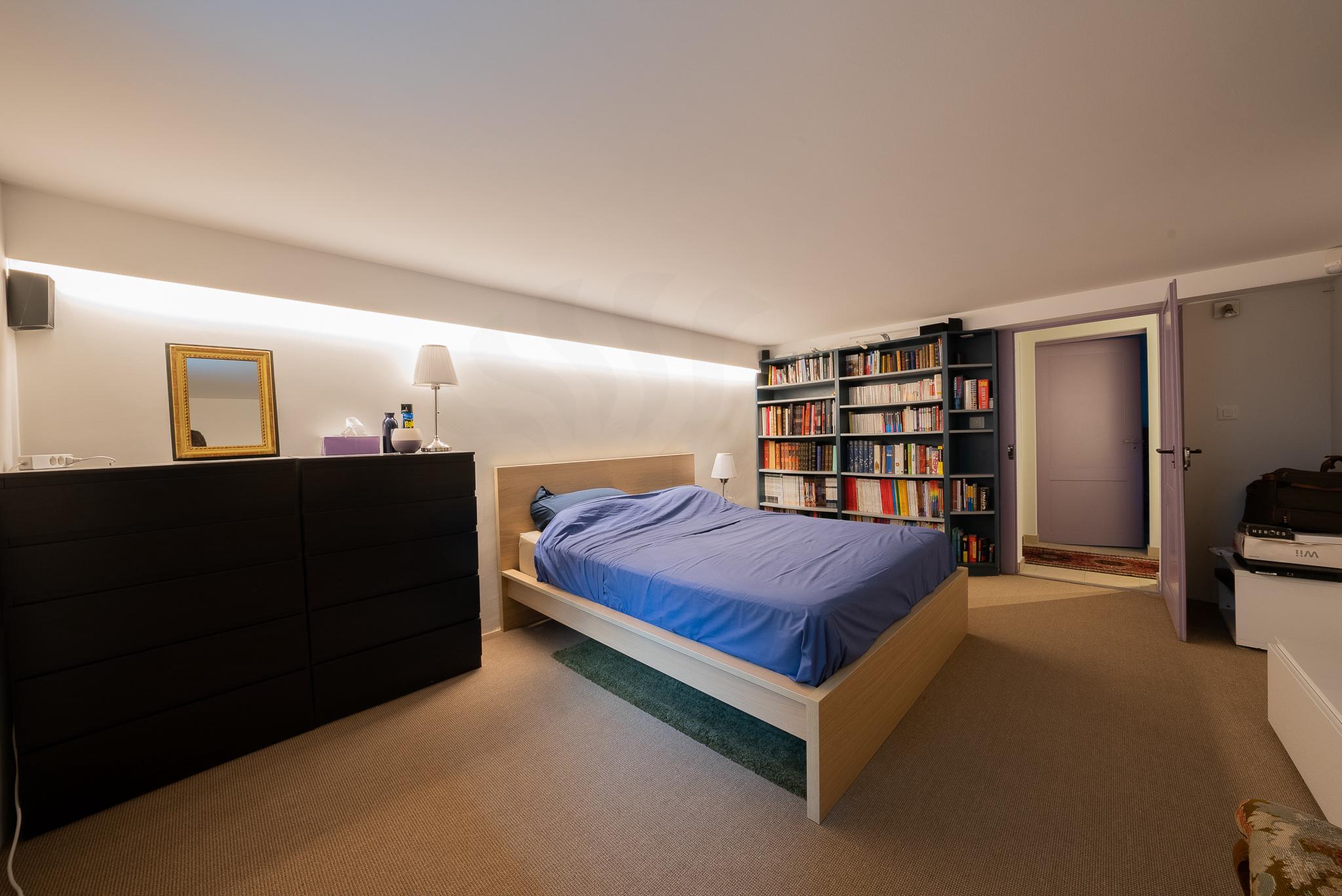 Schlafzimmer mit Dachschräge und Bücherregal