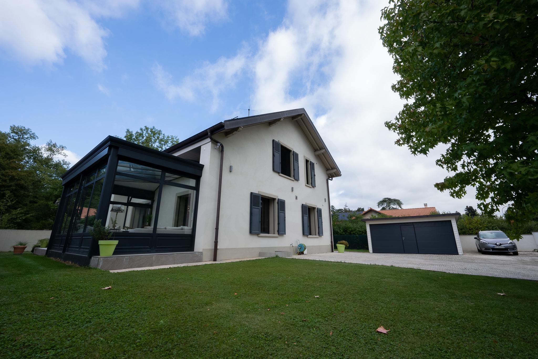 Modernes Einfamilienhaus mit verglastem Anbau und Garten