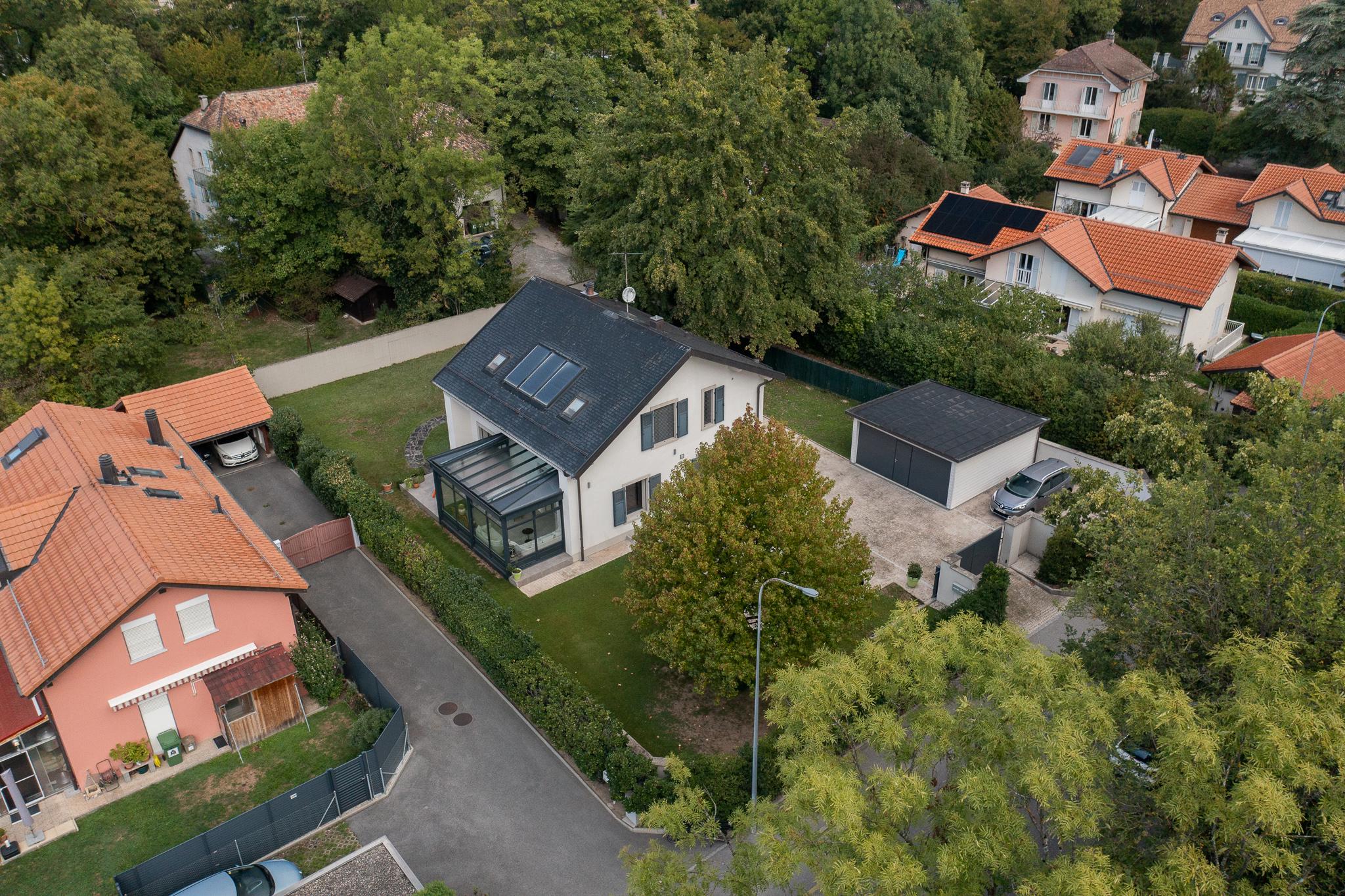 Luftaufnahme eines Einfamilienhauses in grüner Wohngegend