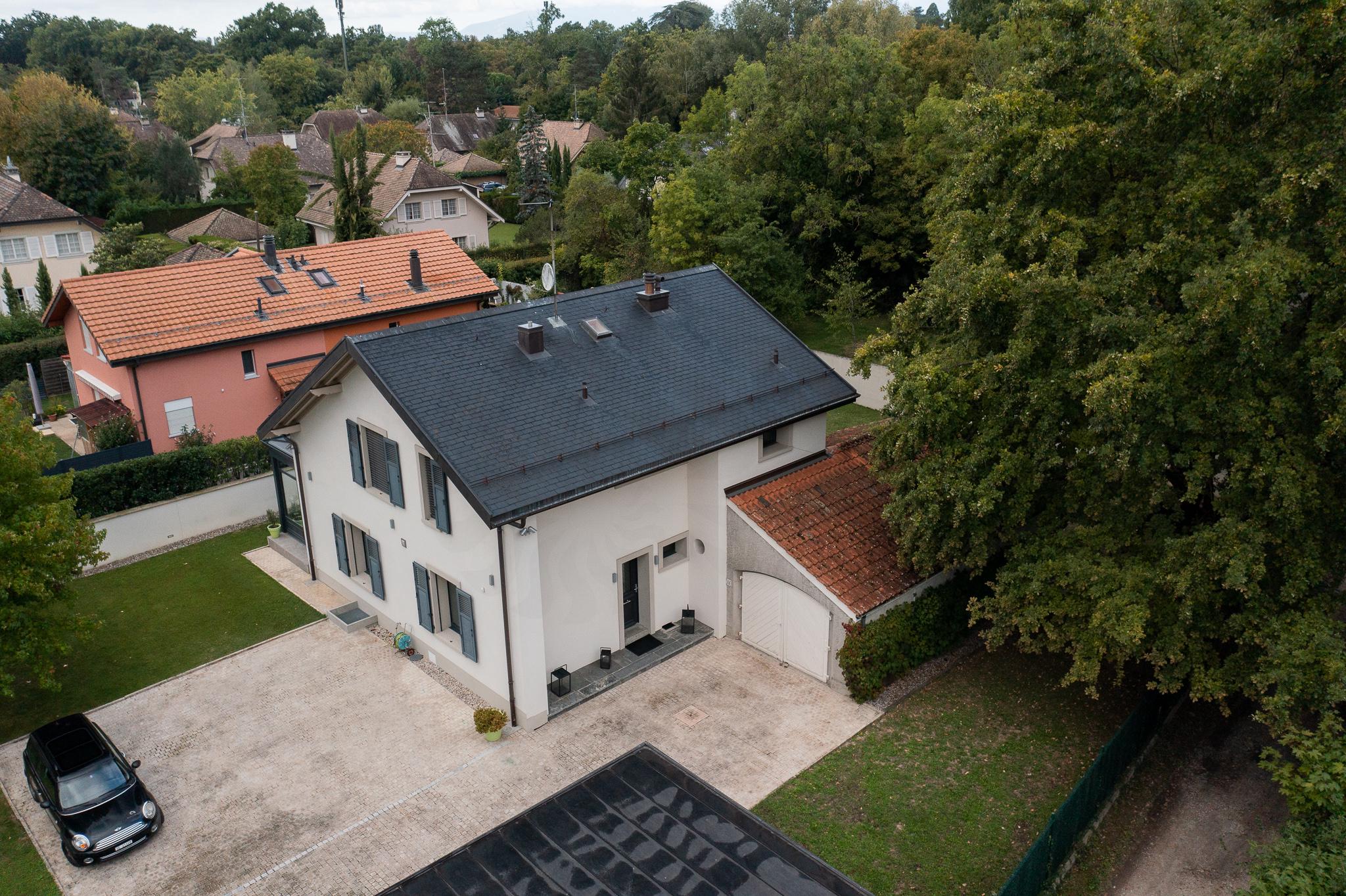 Luftaufnahme eines Einfamilienhauses mit Garage und Garten