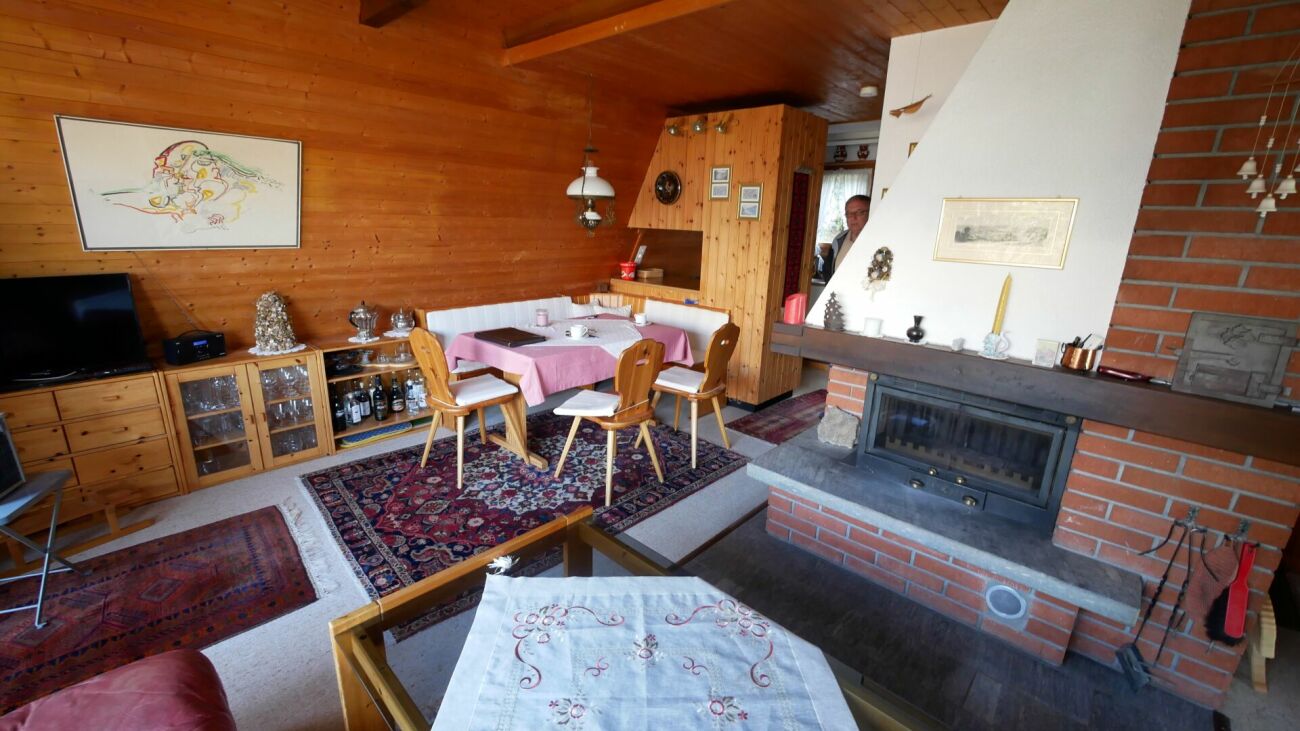 Gemütlicher Wohn- und Essbereich mit Kamin und Holzverkleidung