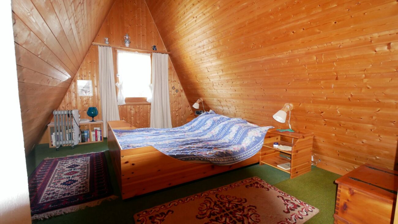 Gemütliches Dachgeschoss-Schlafzimmer mit Holzverkleidung