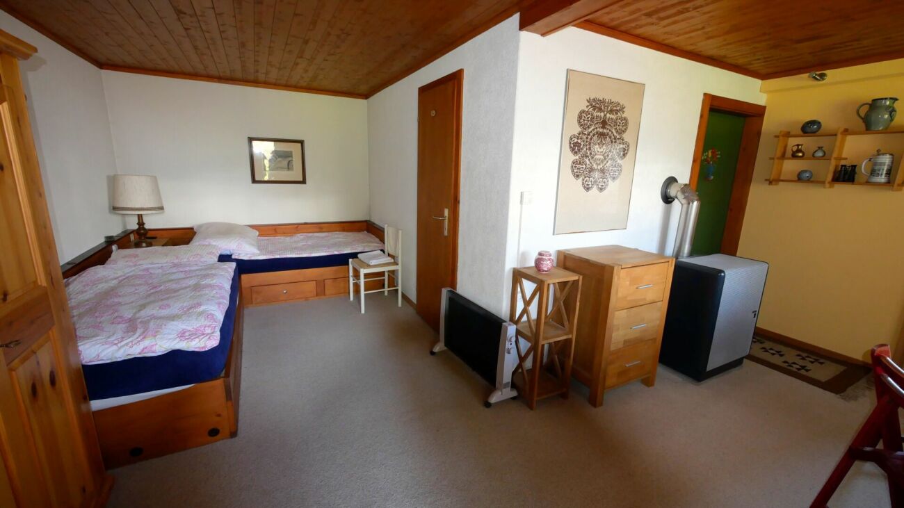 Gemütliches Schlafzimmer mit Holzdecke und Einzelbetten