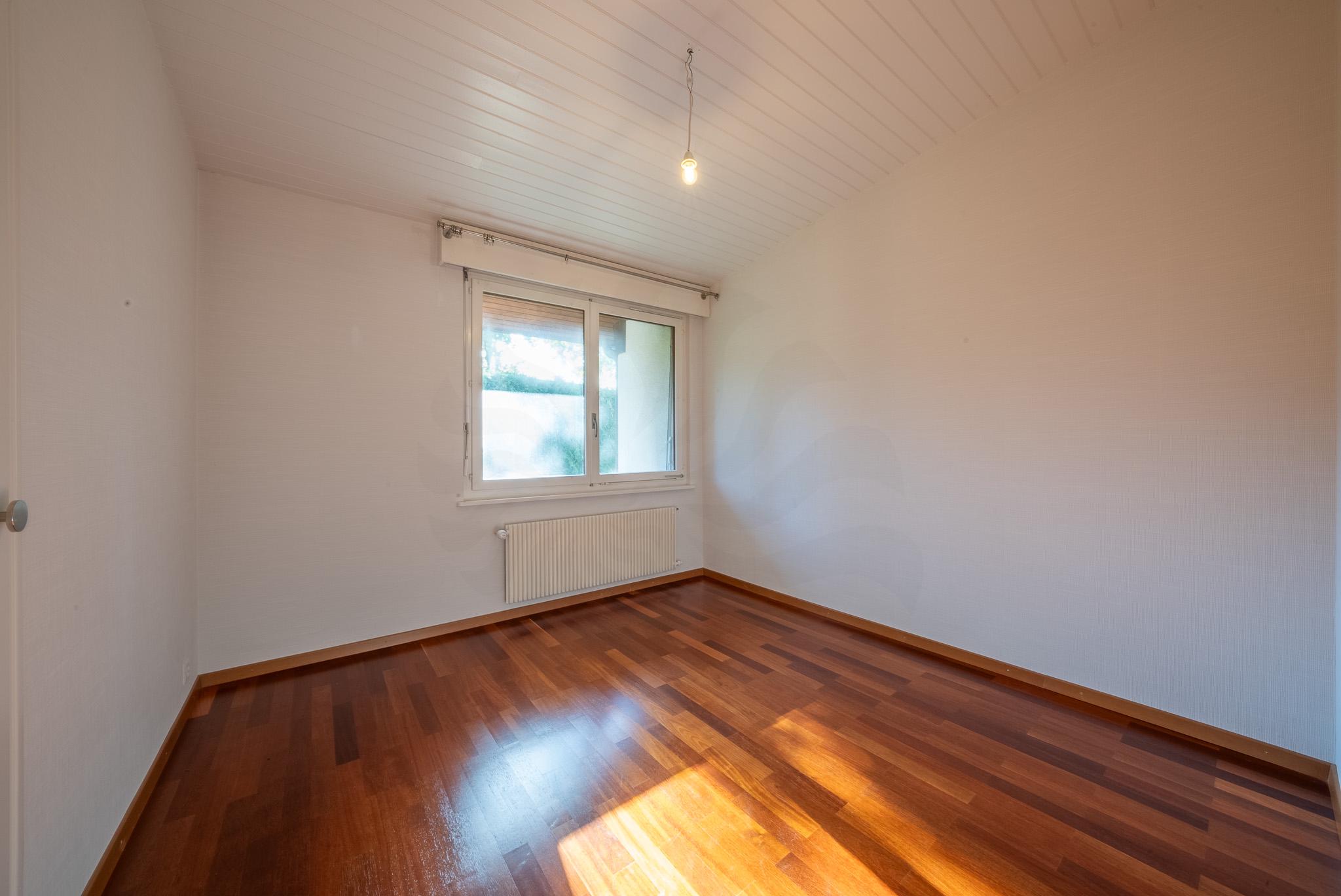 Leerer Raum mit Holzparkett und Fenster