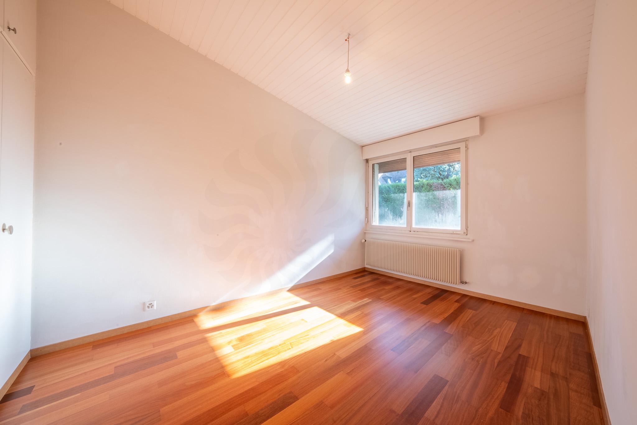 Leeres, helles Zimmer mit Holzfußboden