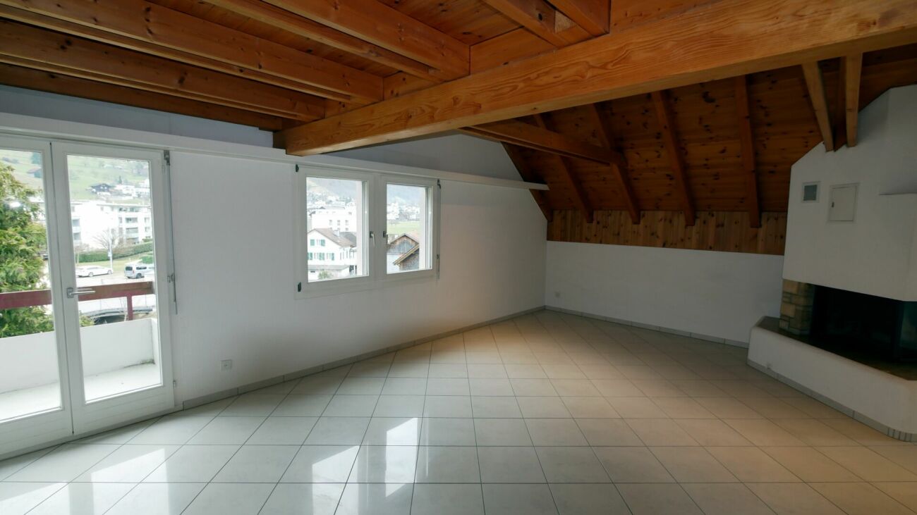 Dachgeschoss-Wohnraum mit Holzdecke und Kamin