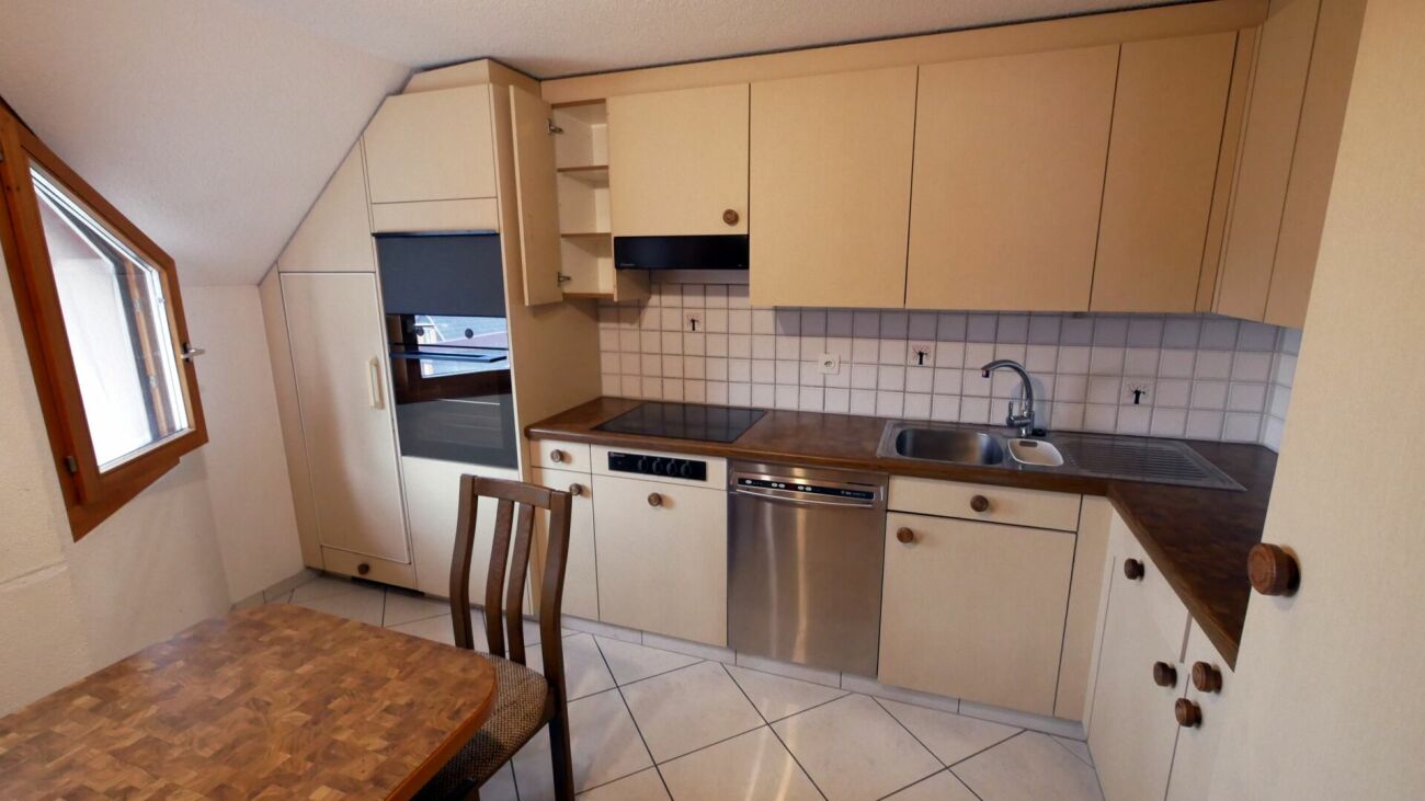 Kleine Einbauküche mit Esstisch unter Dachschräge