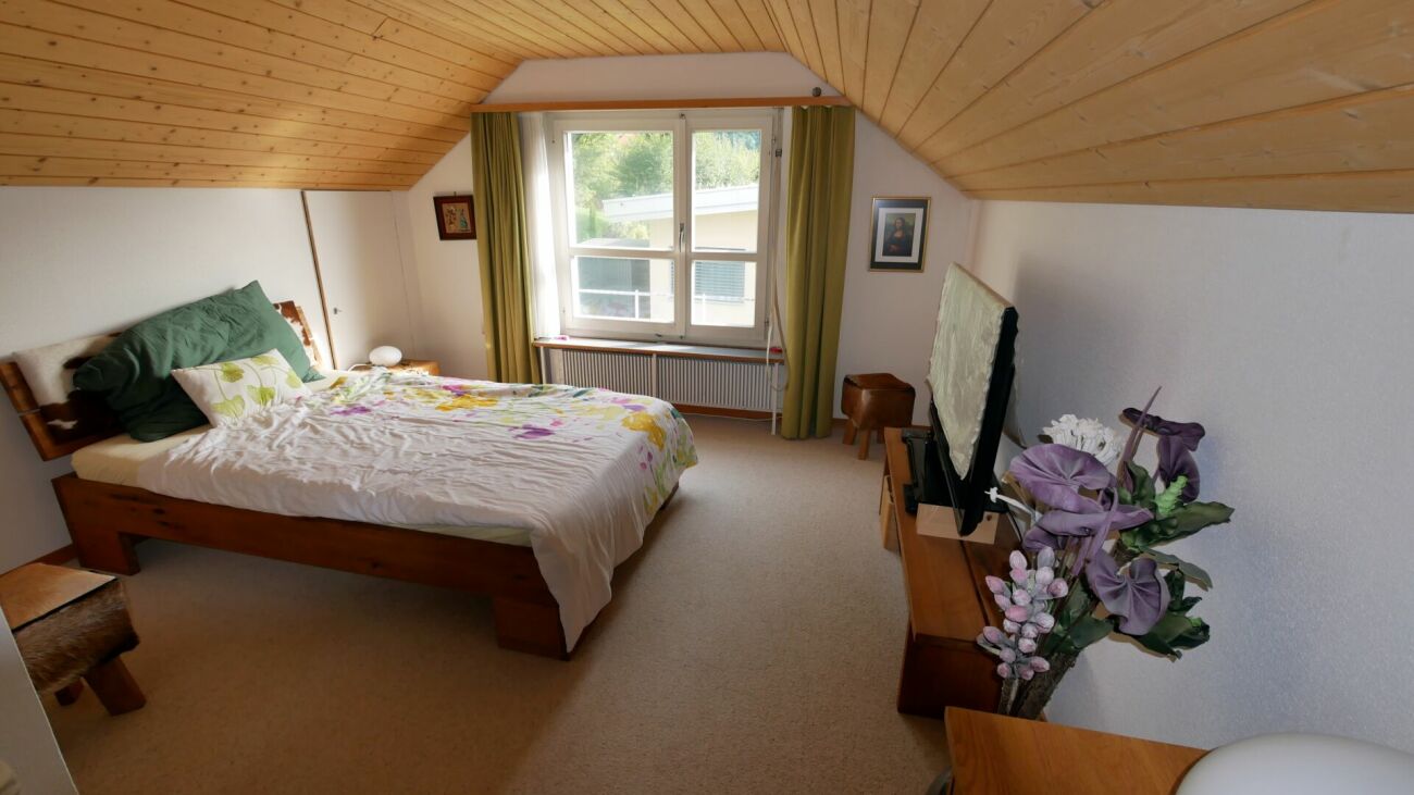 Dachgeschoss-Schlafzimmer mit Holzbalkendecke