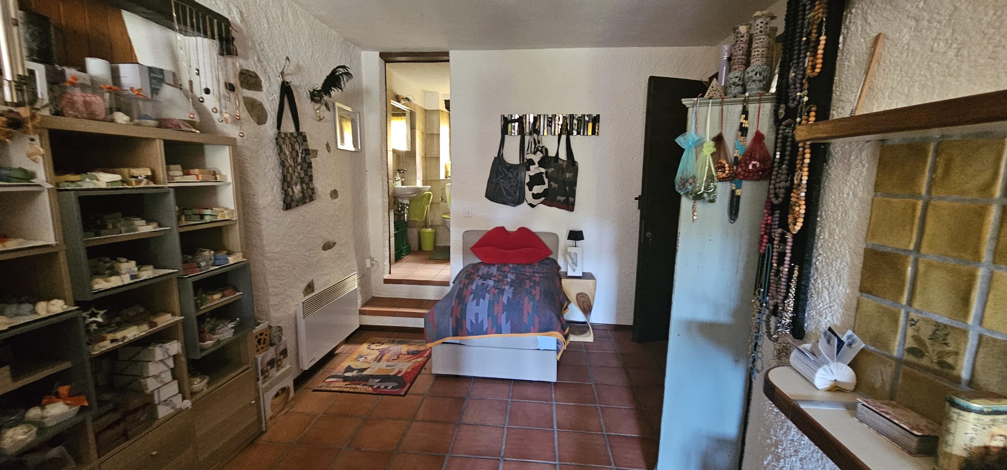 Kleiner dekorierter Raum mit Bett und Regalen