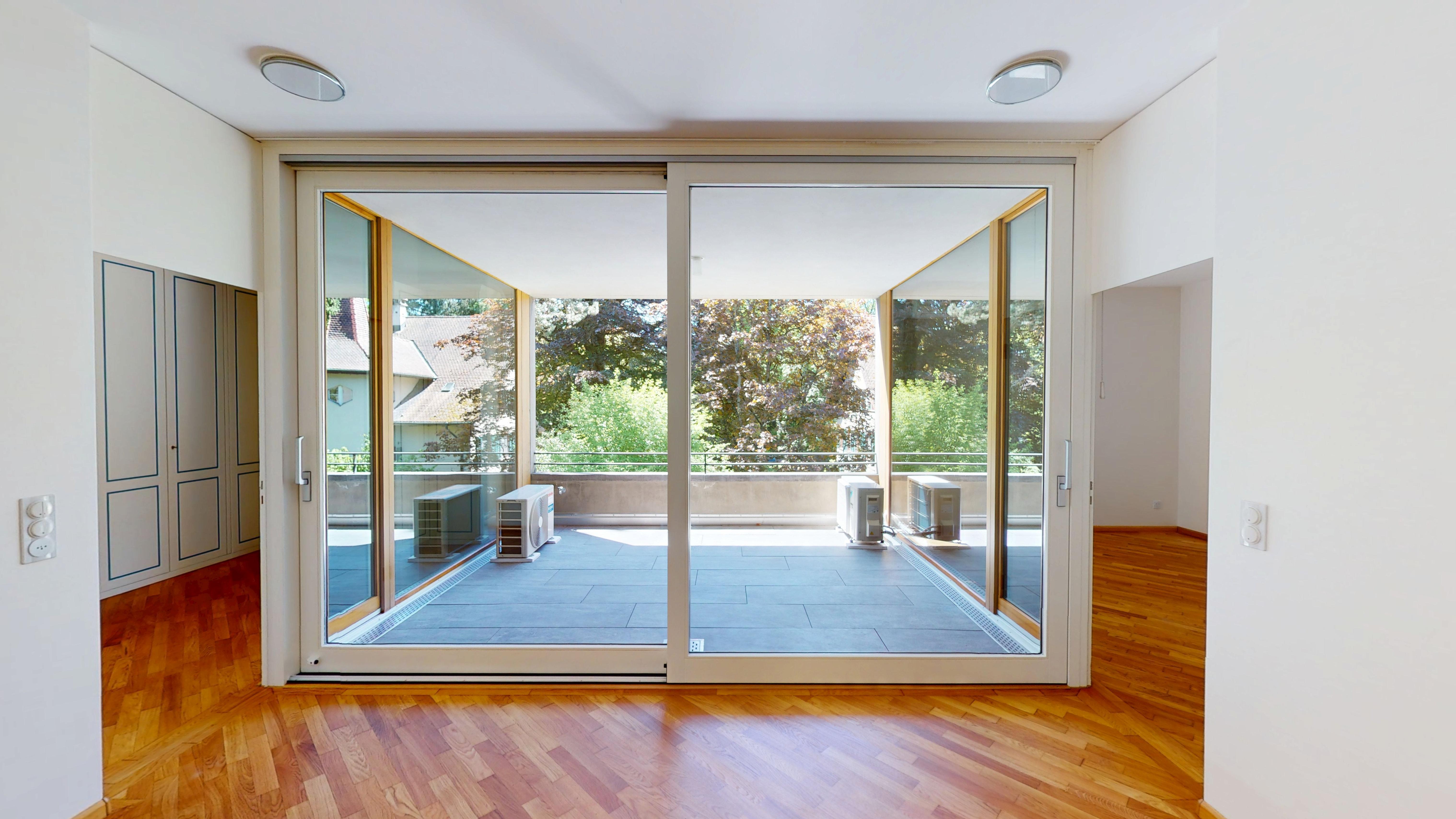 Heller Wohnraum mit großer Glasfront zum Balkon