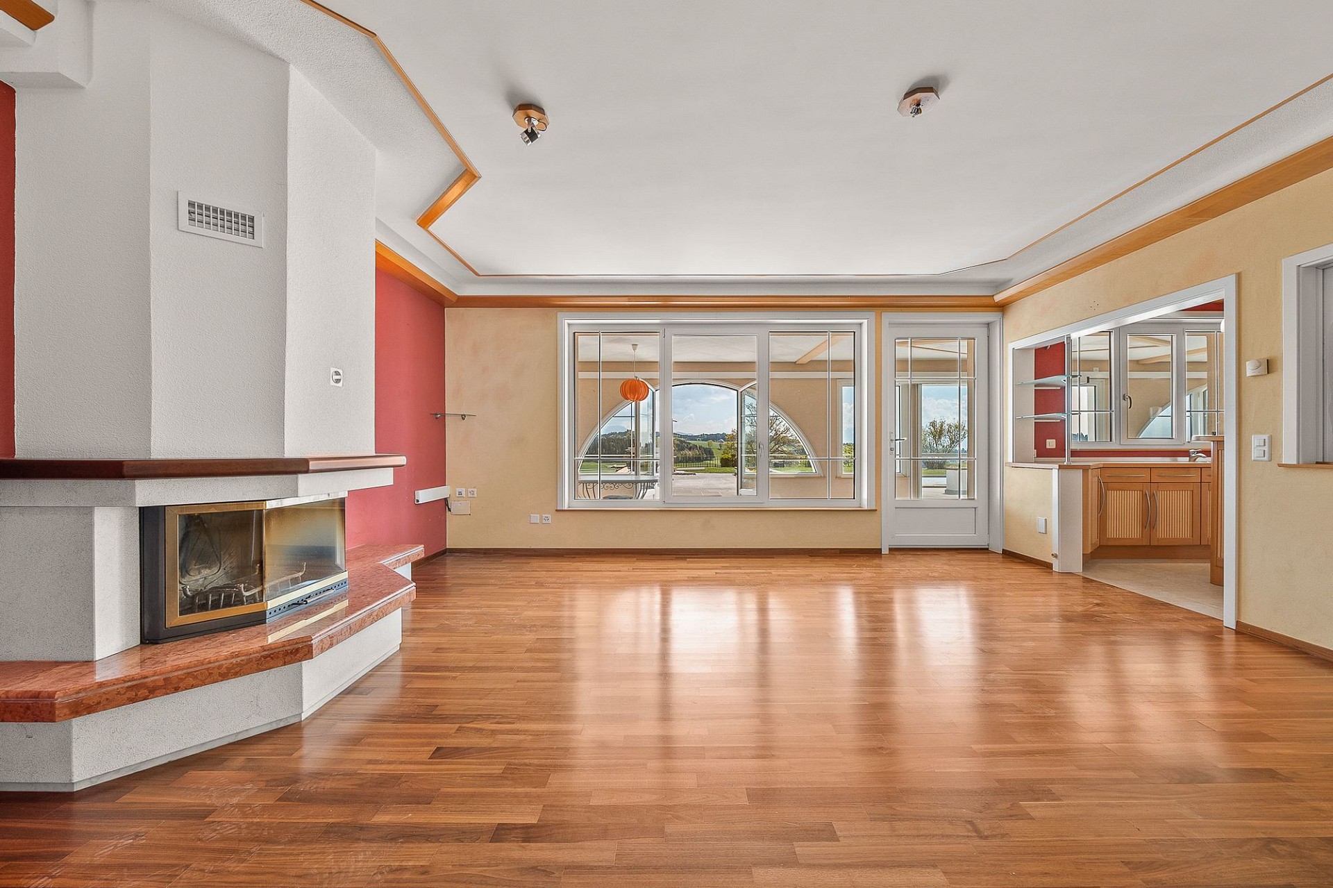 Großer Wohnraum mit Kamin und Blick ins Grüne