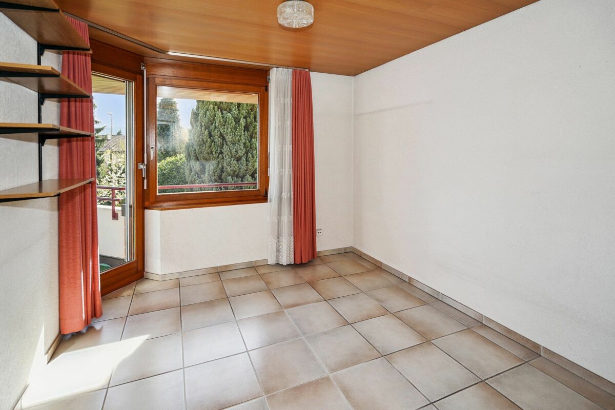 Leerer Wohnraum mit Balkon und Holzfenstern
