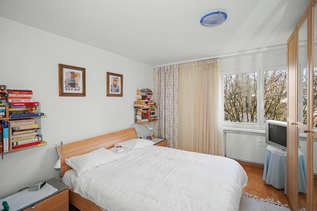 Helles Schlafzimmer mit Holzmöbeln und Blick ins Grüne