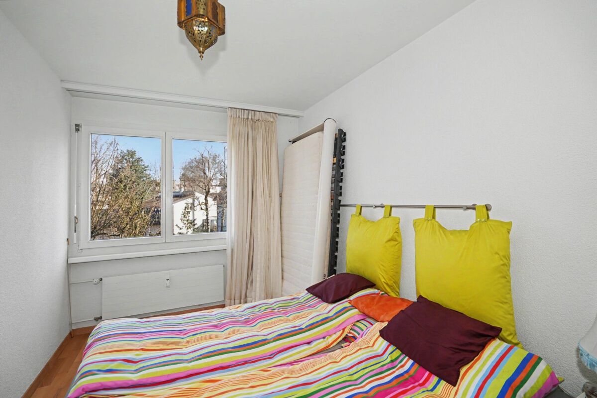 Helles Schlafzimmer mit bunt gestreiftem Bett