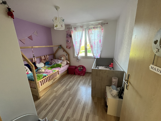 Kinderzimmer mit Fenster und Holzhausbett