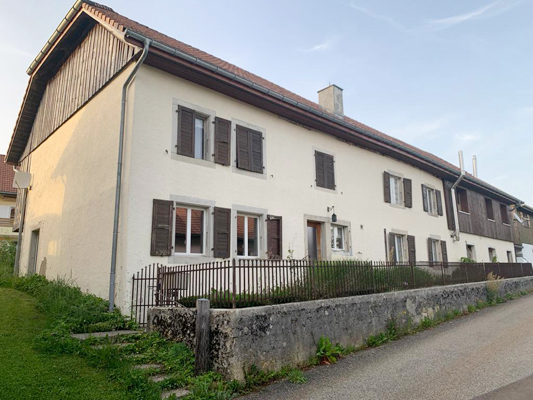 Wohnhaus mit Putzfassade und Holzläden