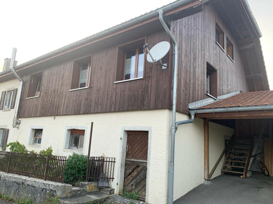 Rustikales Haus mit Holzfassade und Carport