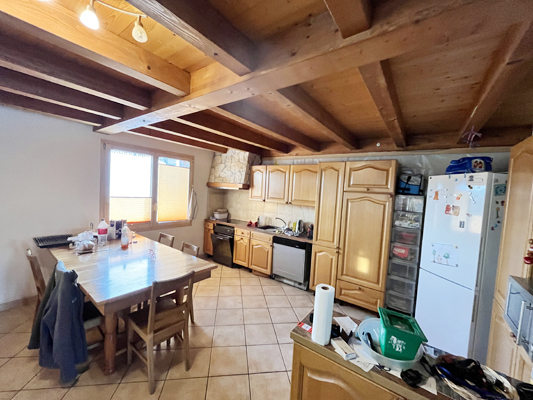 Küche mit Essbereich und sichtbarer Holzdecke