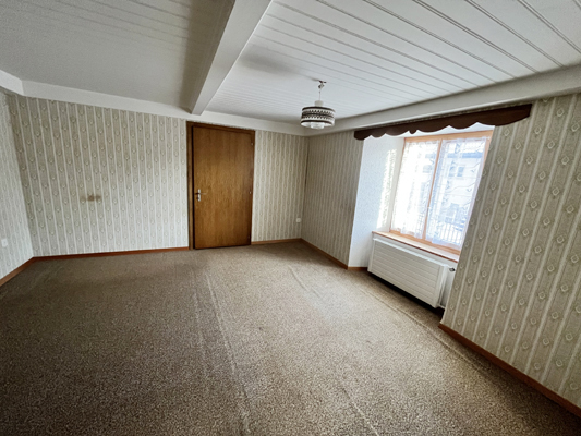 Leeres Zimmer mit Teppichboden und Fenster