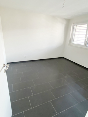 Leerer Raum mit Fliesenboden und Fenster