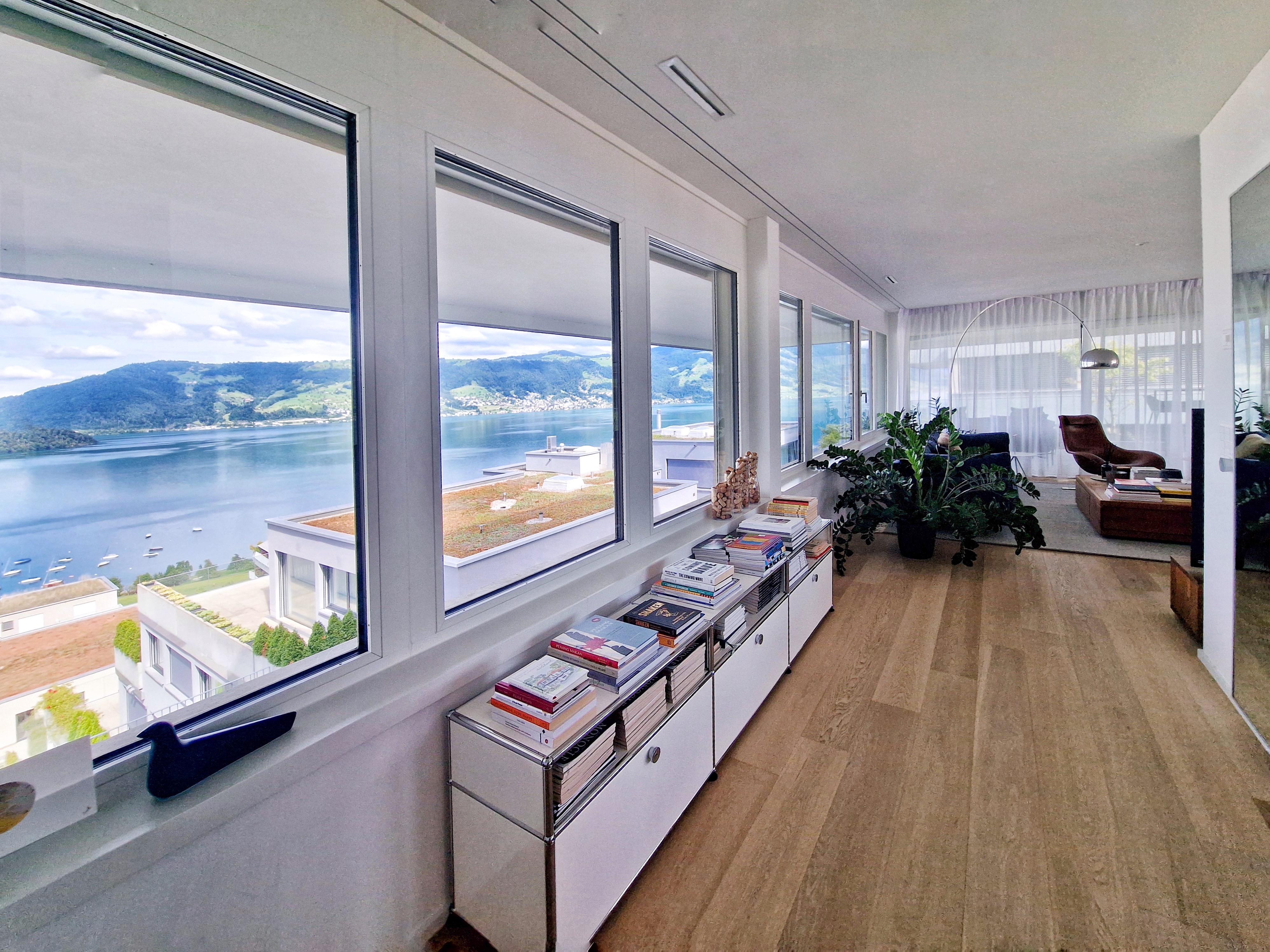 Wohnraum mit Panoramafenstern und Seeblick
