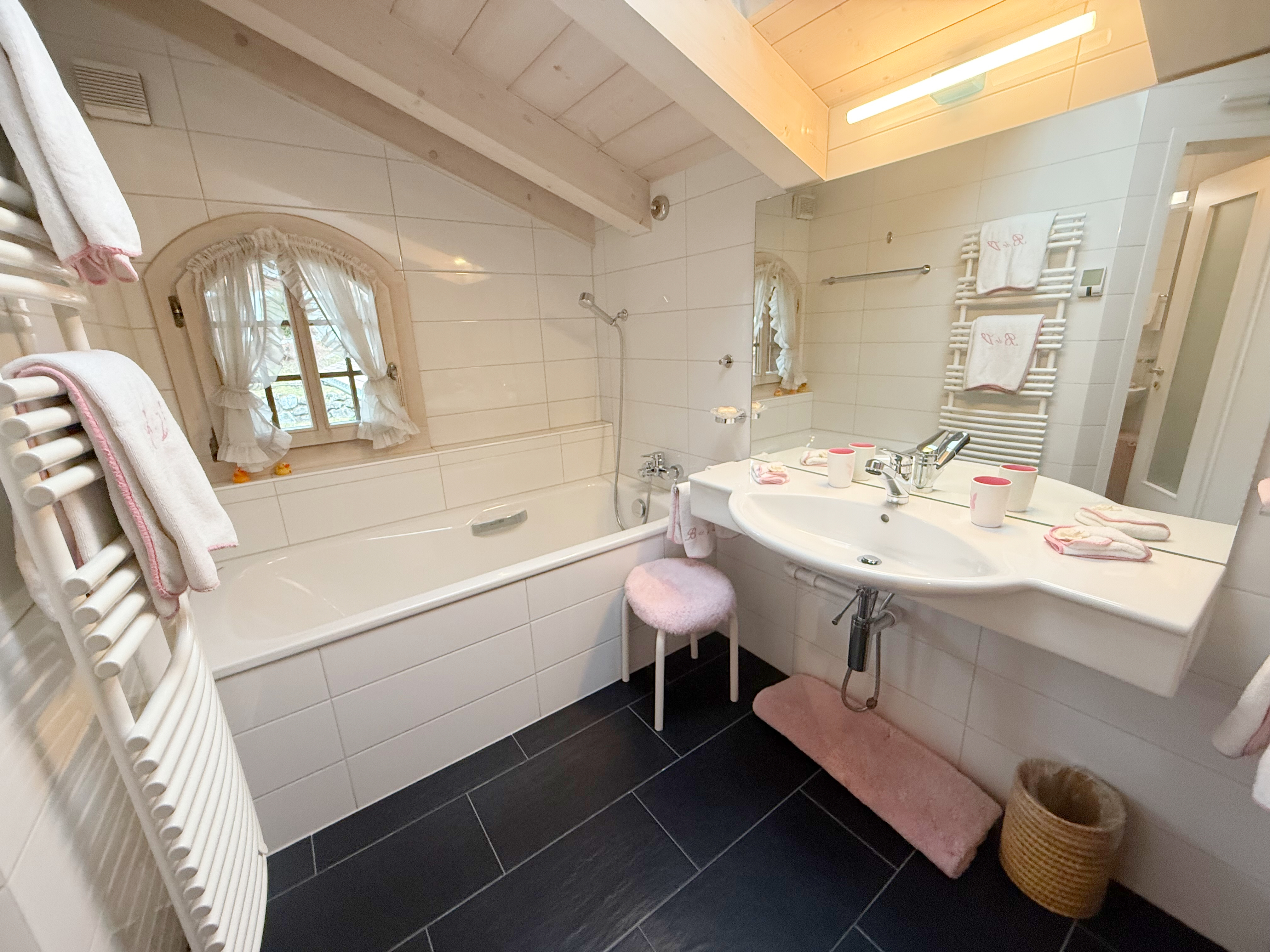 Hell eingerichtetes Badezimmer mit Badewanne und Dachschräge