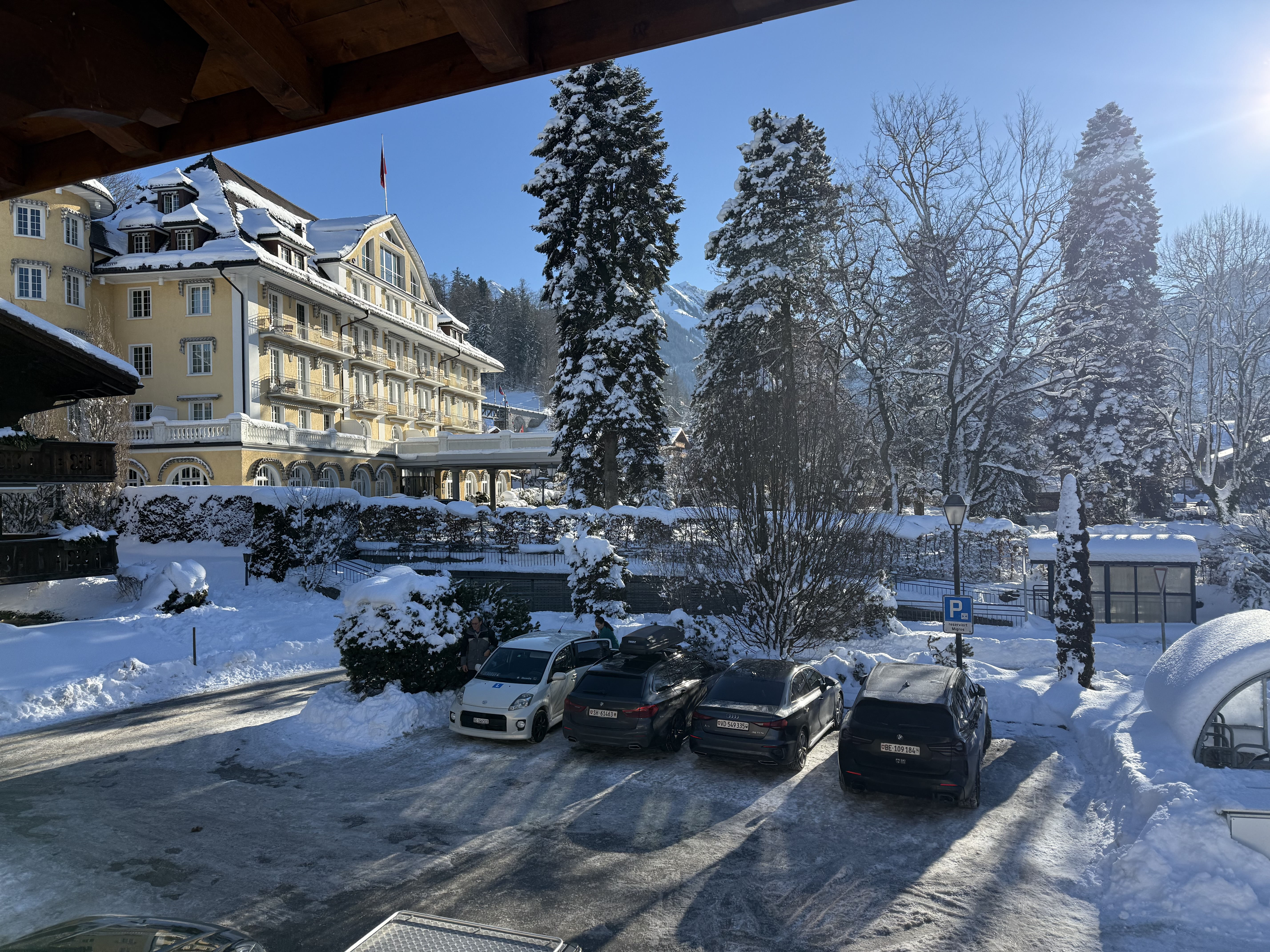 Schneevorhof mit Hotelgebäude und Bergblick