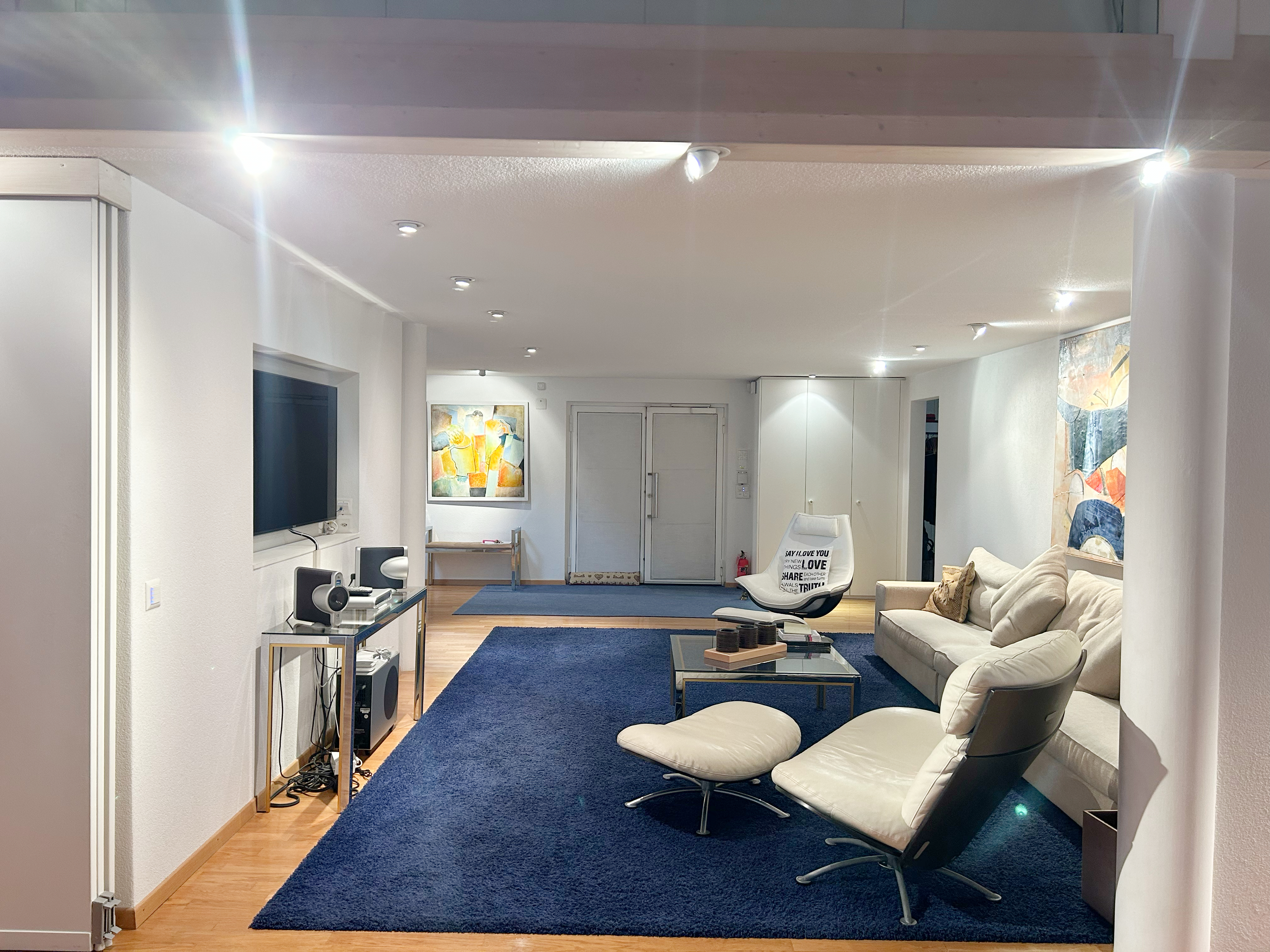 Modernes, helles Wohnzimmer mit blauen Teppichen