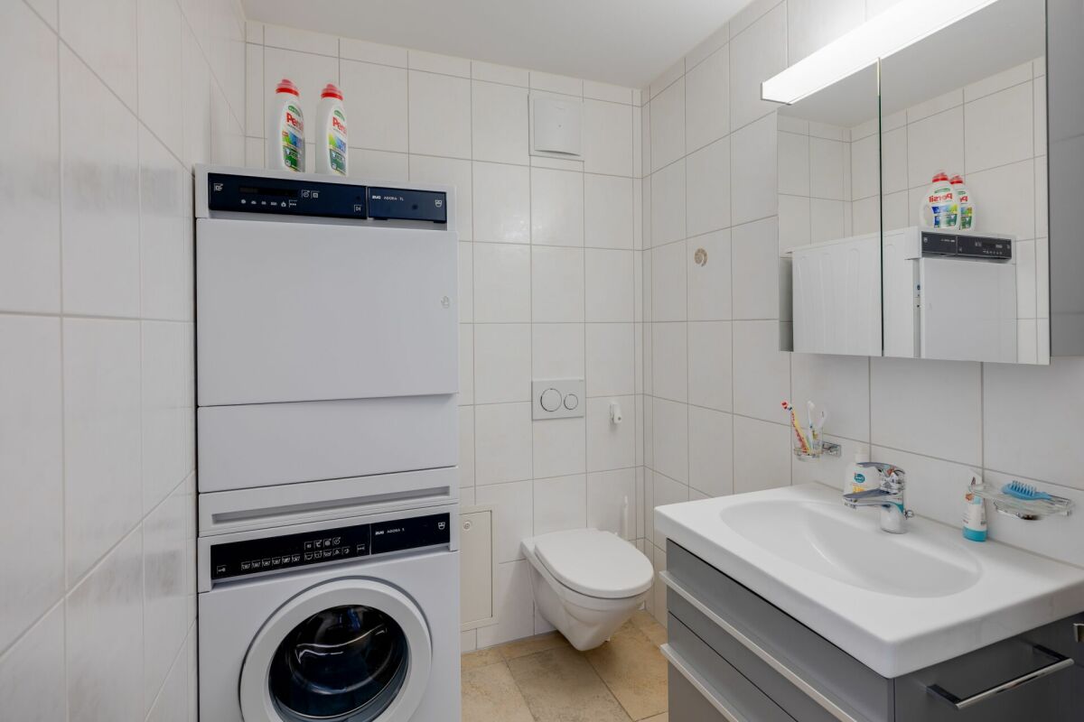 Badezimmer mit Waschtisch, WC und Waschmaschine