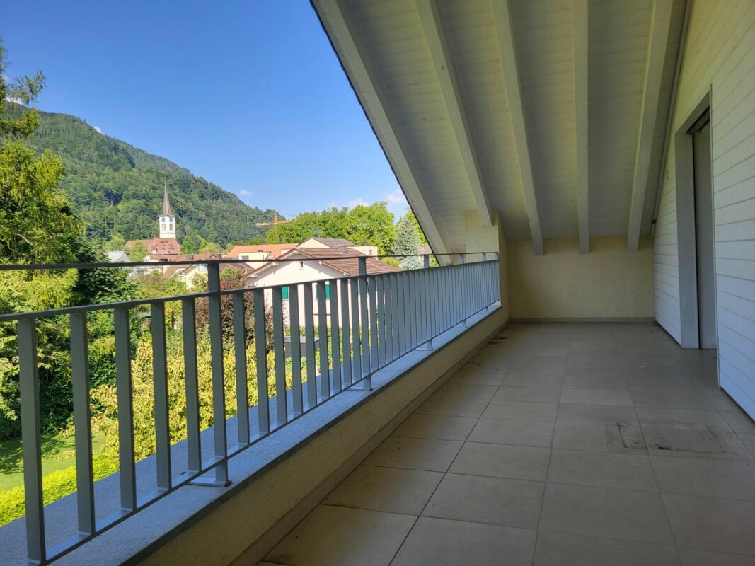 Überdachter Balkon mit Berg- und Dorfblick