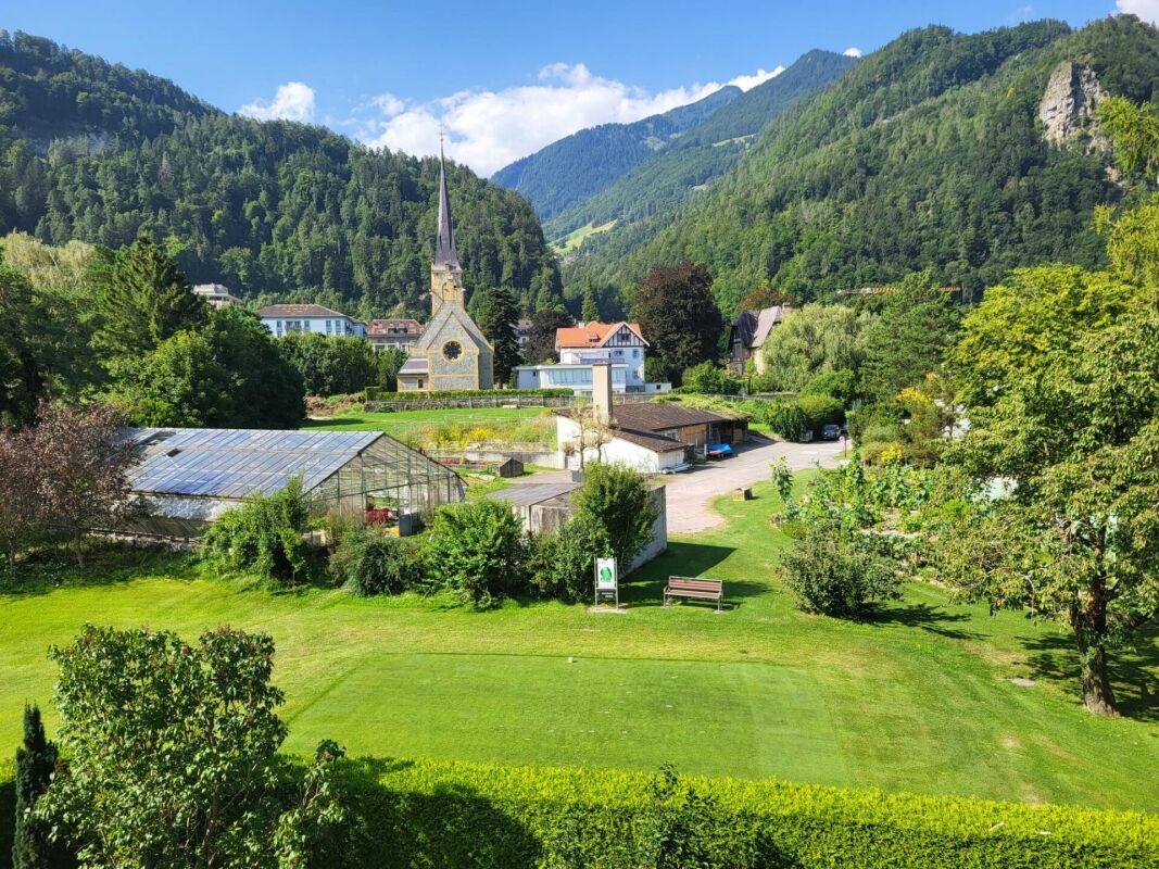 Alpine Landschaft mit Kirche und Garten