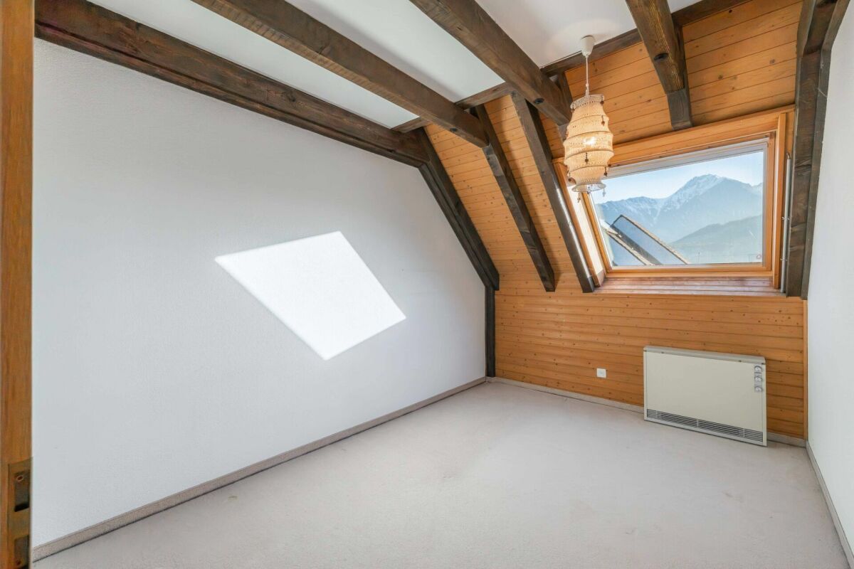 Dachzimmer mit Holzverkleidung und Alpenblick