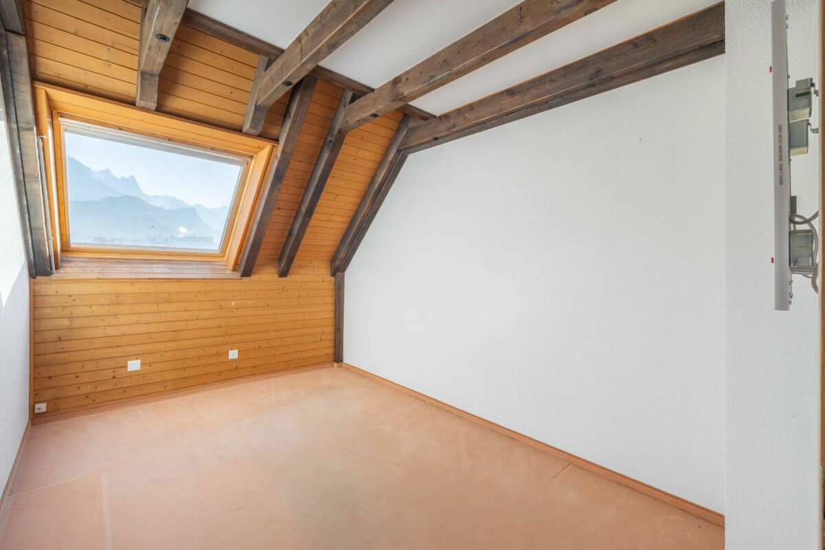 Dachzimmer mit Sichtbalken und Dachfenster