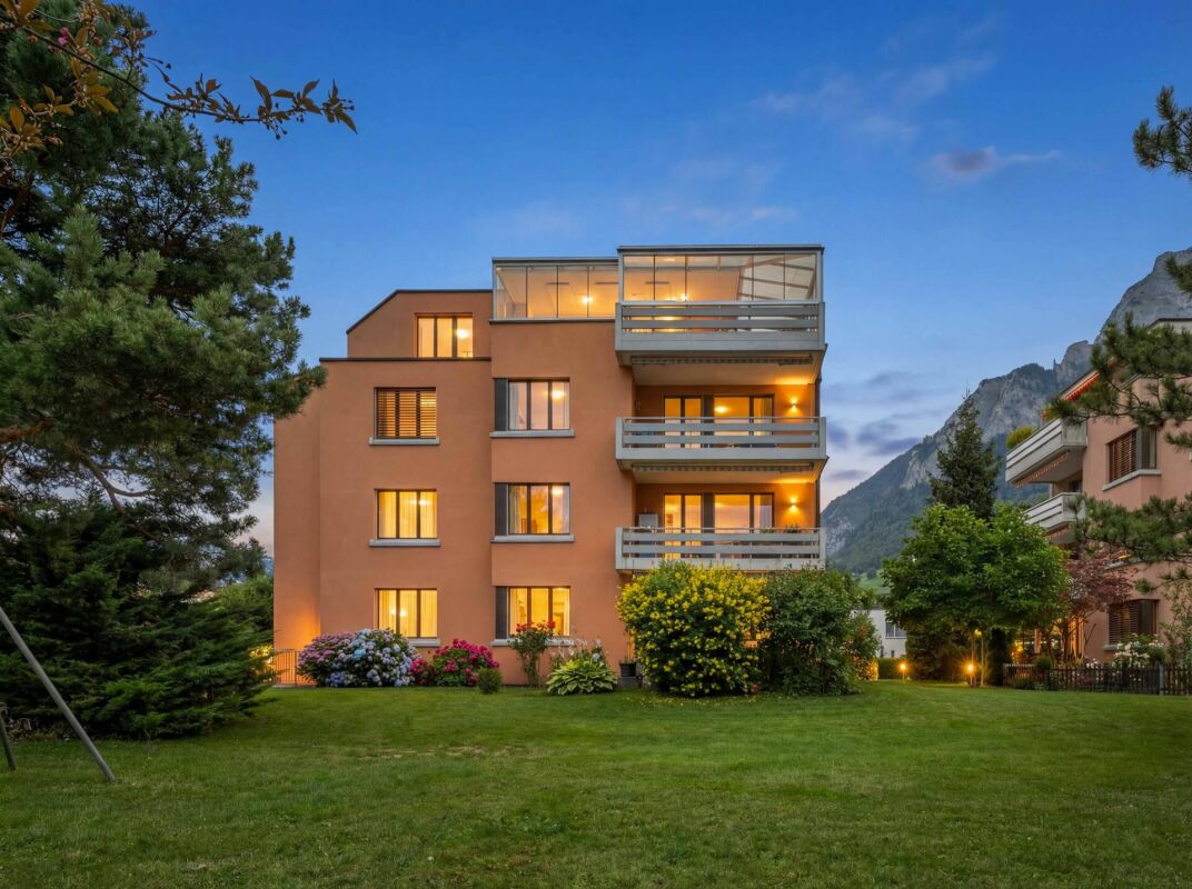 Mehrfamilienhaus mit Alpenblick bei Dämmerung