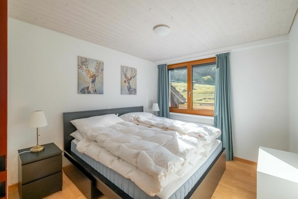 Helles Schlafzimmer mit Doppelbett und Bergblick