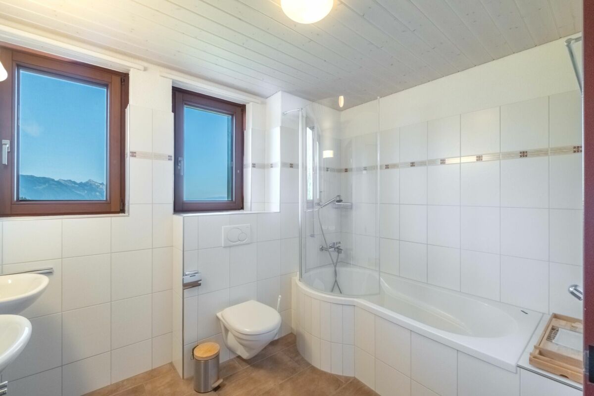 Modernes Badezimmer mit Badewanne und Blick ins Gebirge