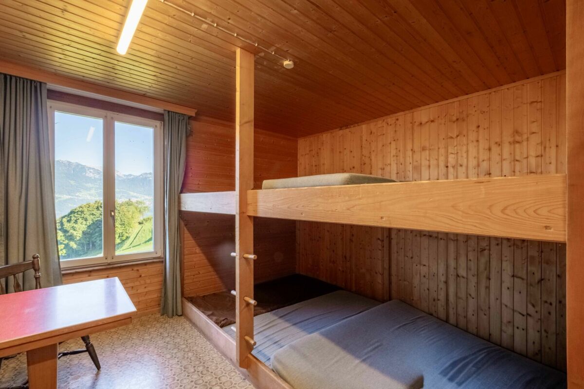 Rustikales Schlafzimmer mit Etagenbett und Bergblick