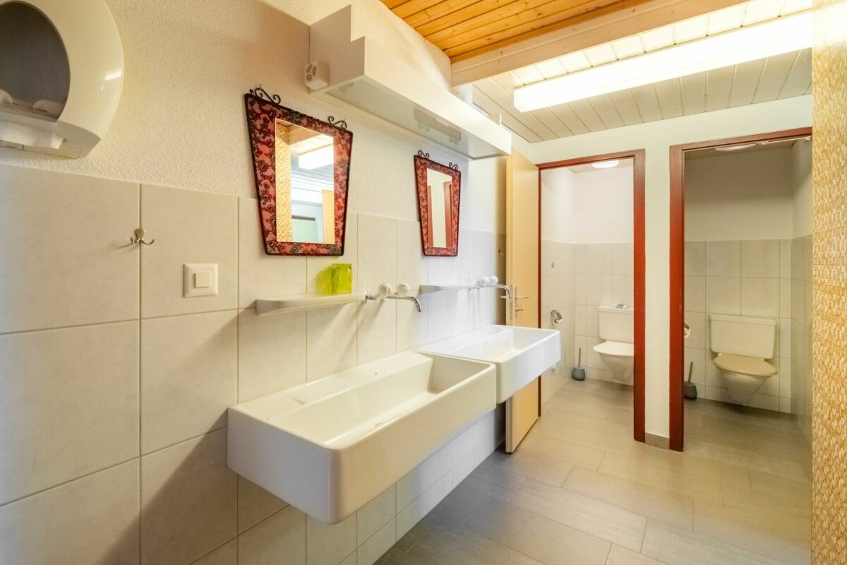 Badezimmer mit zwei Waschbecken und separaten WC-Räumen