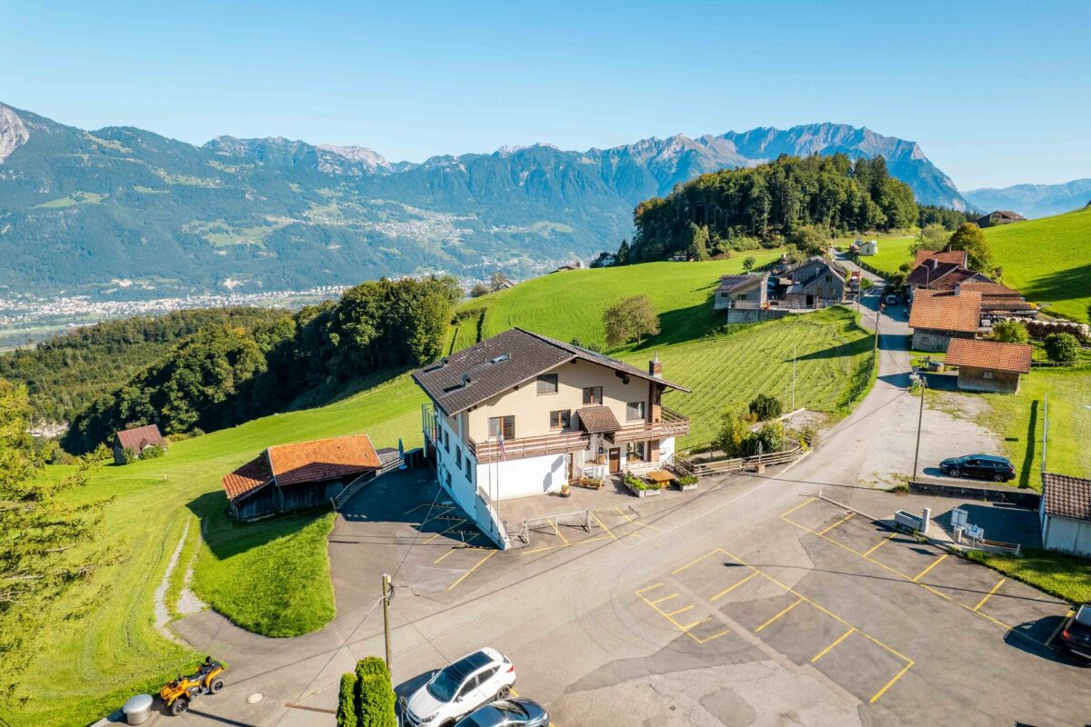 Alpine Berglandschaft mit Wohnhaus und Parkplatz
