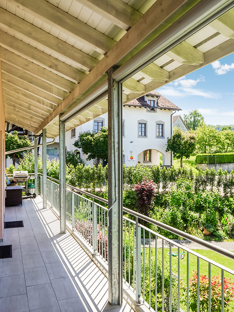 Überdachter Balkon mit Gartenblick